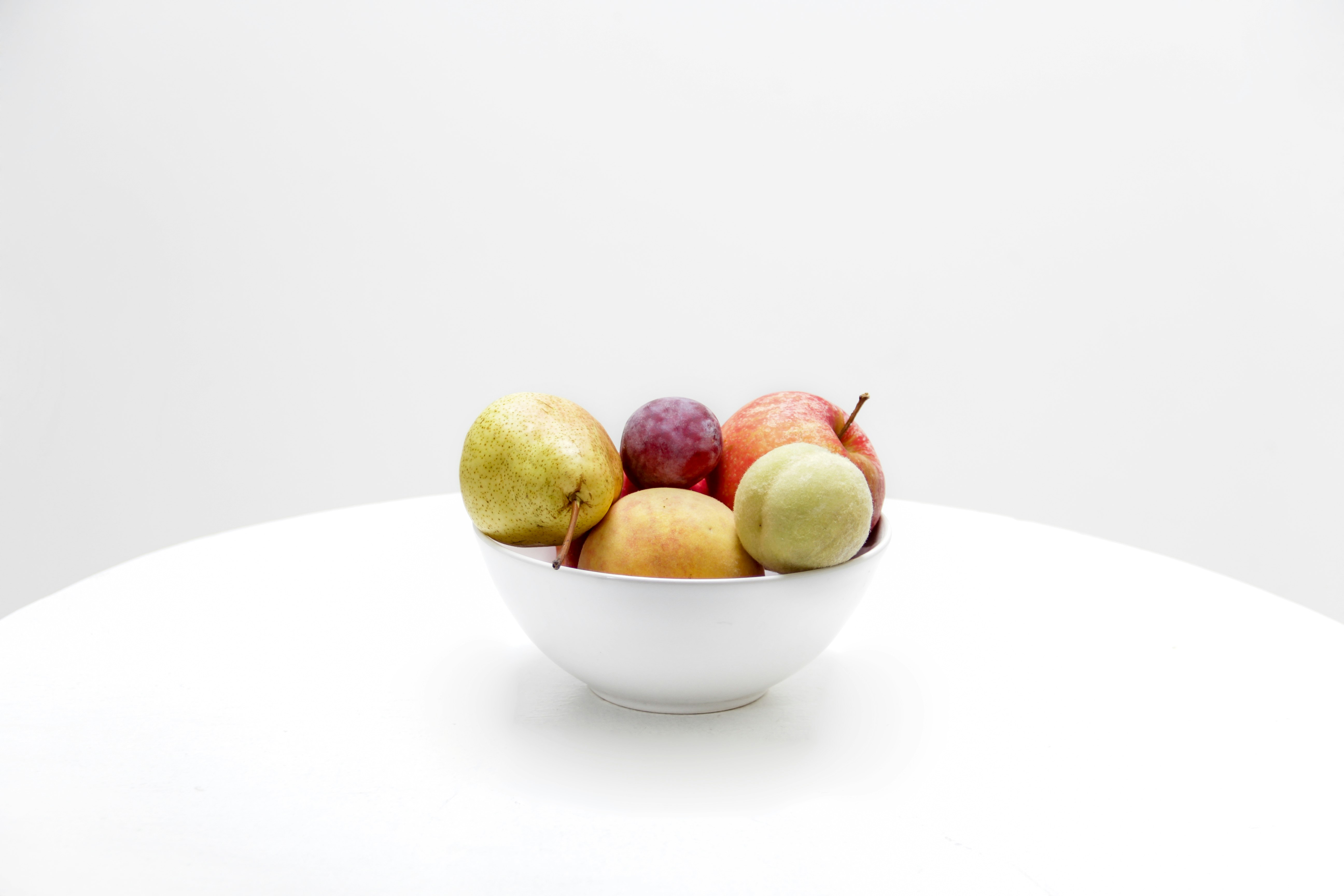 assorted-color fruits on white ceramic bowl